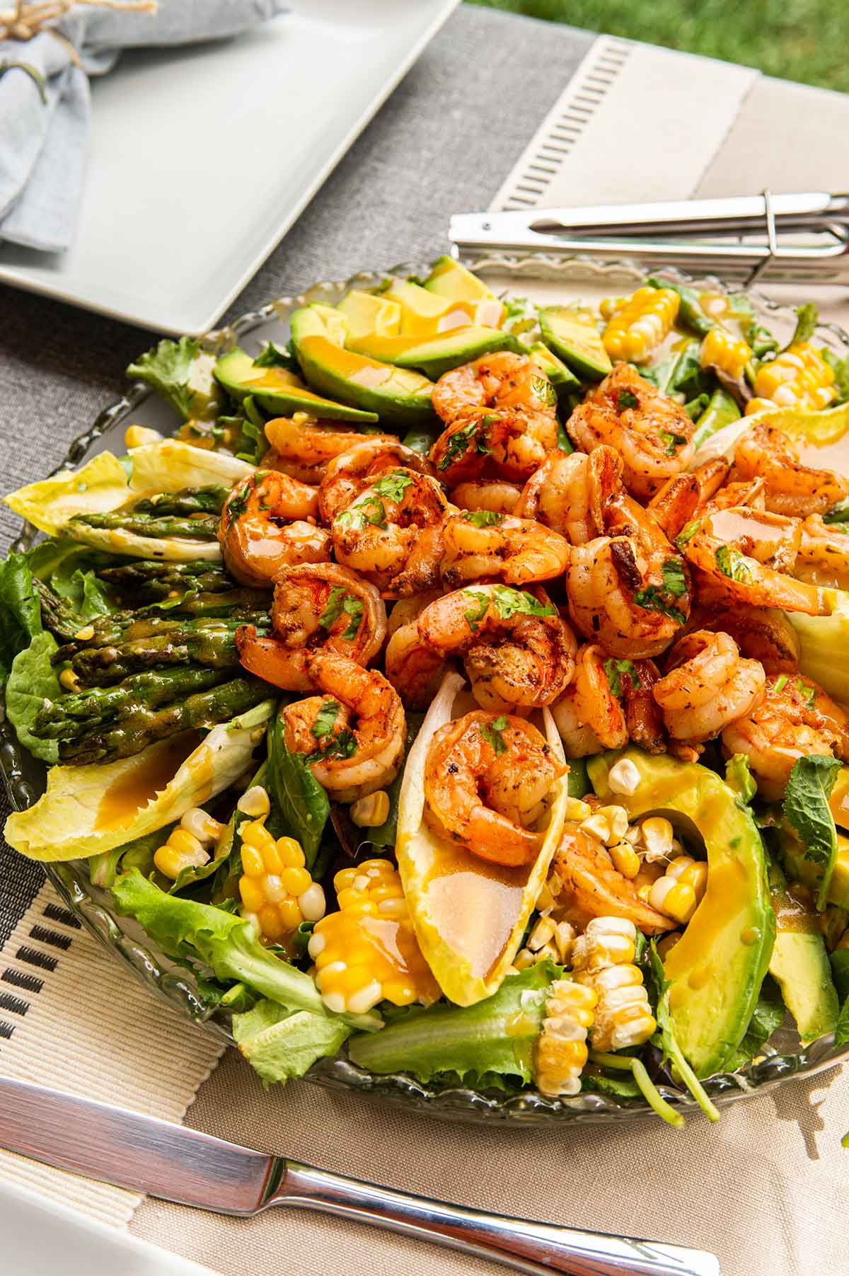 A cilantro lime salad with assorted vegetables on a set table.