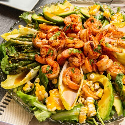 A cilantro lime salad with assorted vegetables on a set table.