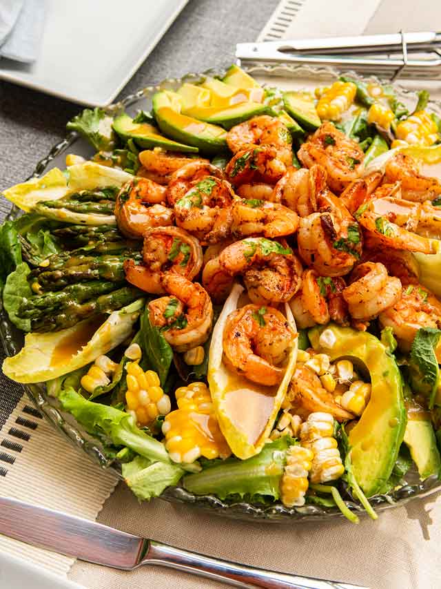 A cilantro lime salad with assorted vegetables on a set table.