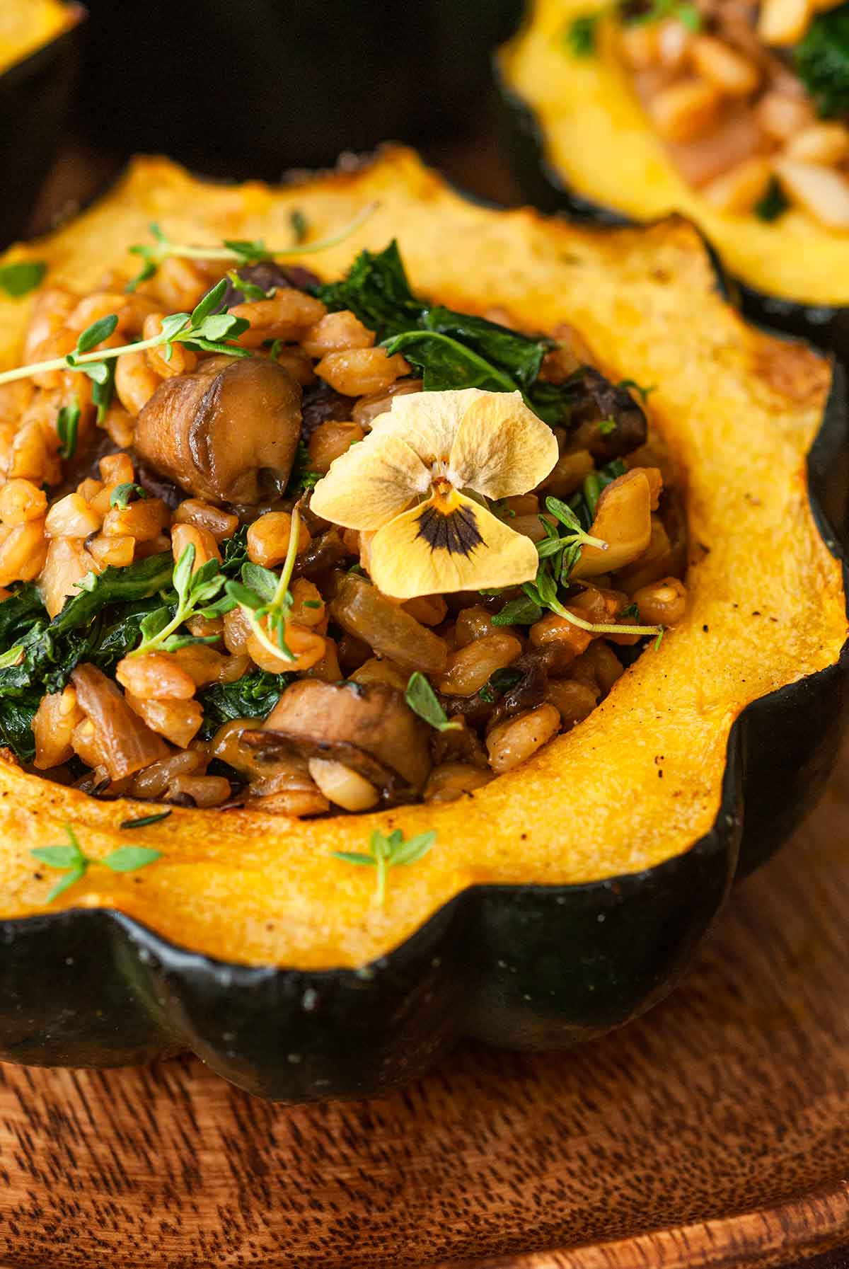 The stuffing on 1 acorn squash, garnished with thyme and a flower.