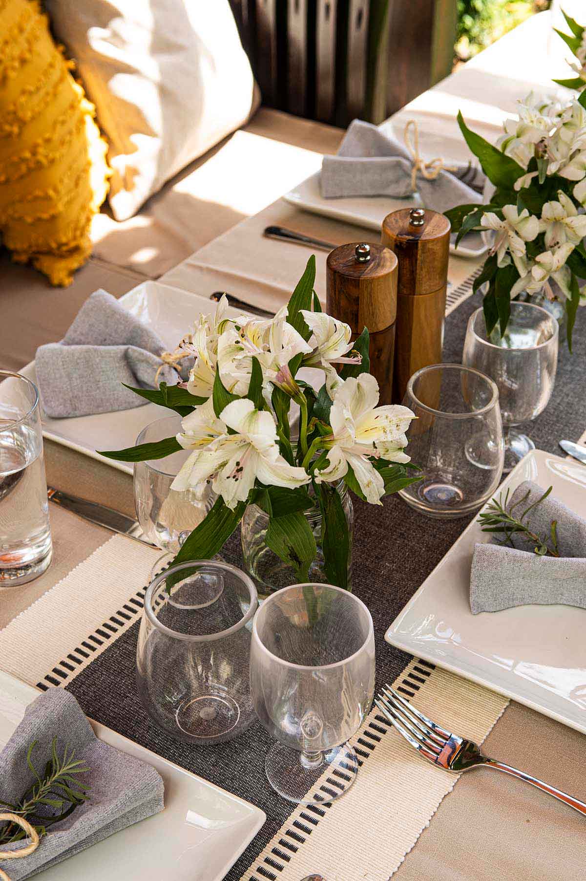 A table set with plates, cups, silverware and flowers.