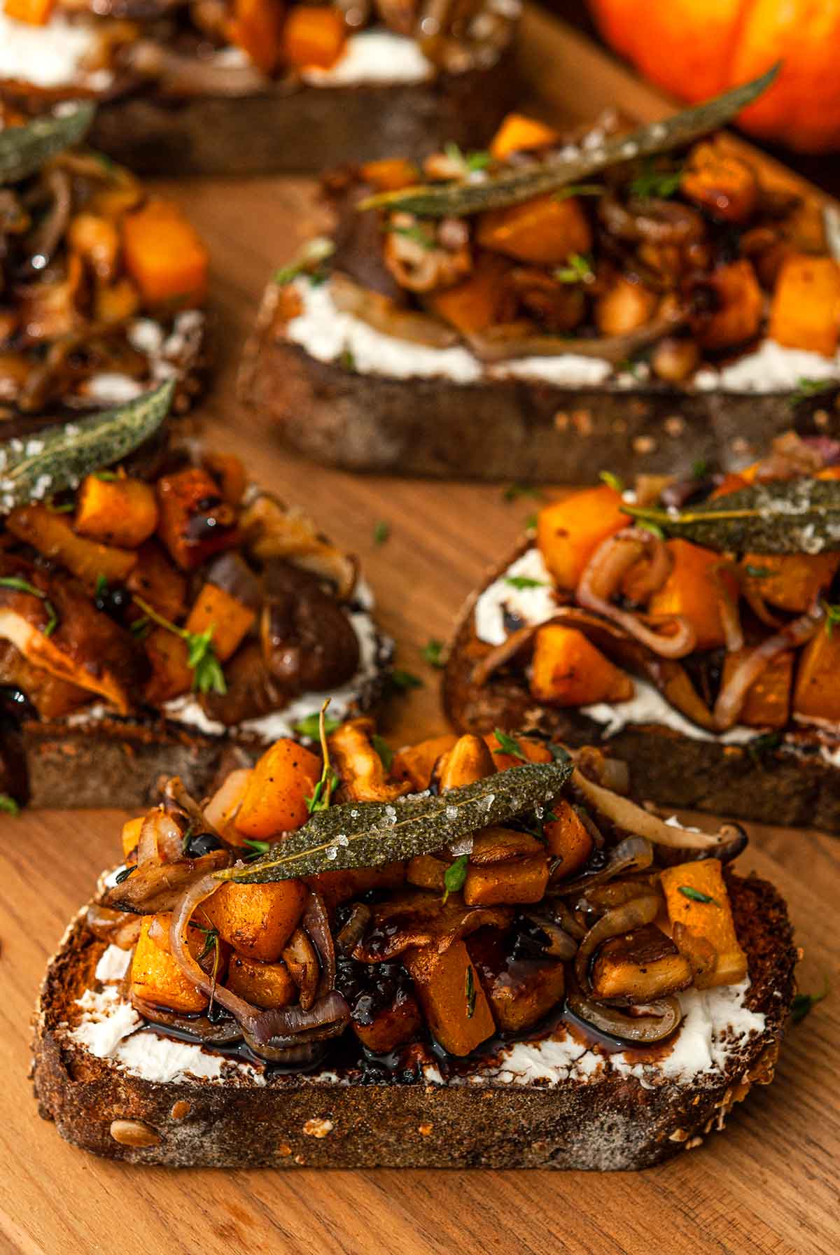 6 maple butternut squash crostini on a wooden cutting board.