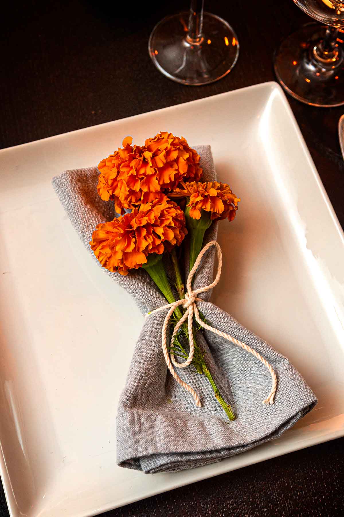 A bouquet of marigolds in a napkin on a plate.