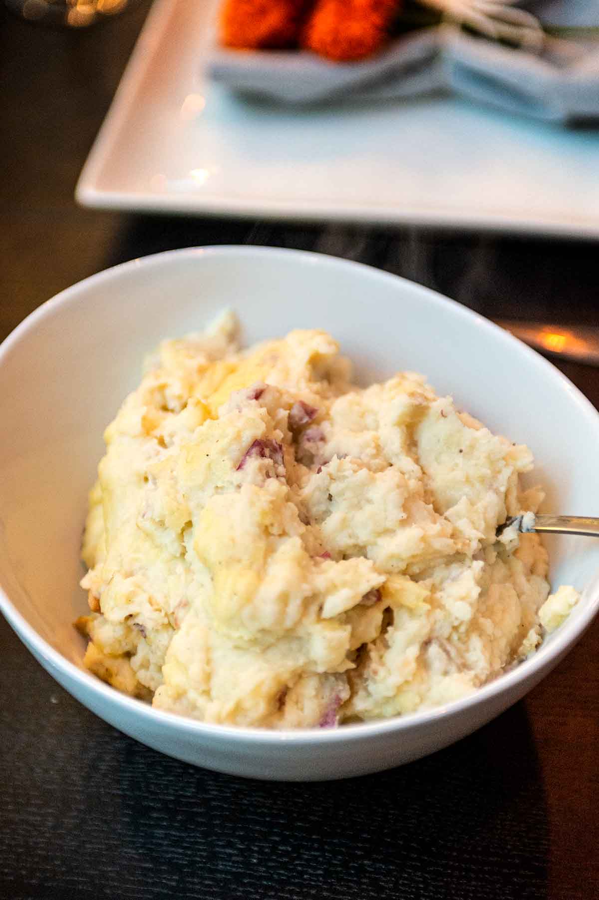 A bowl of mashed potatoes on a table.