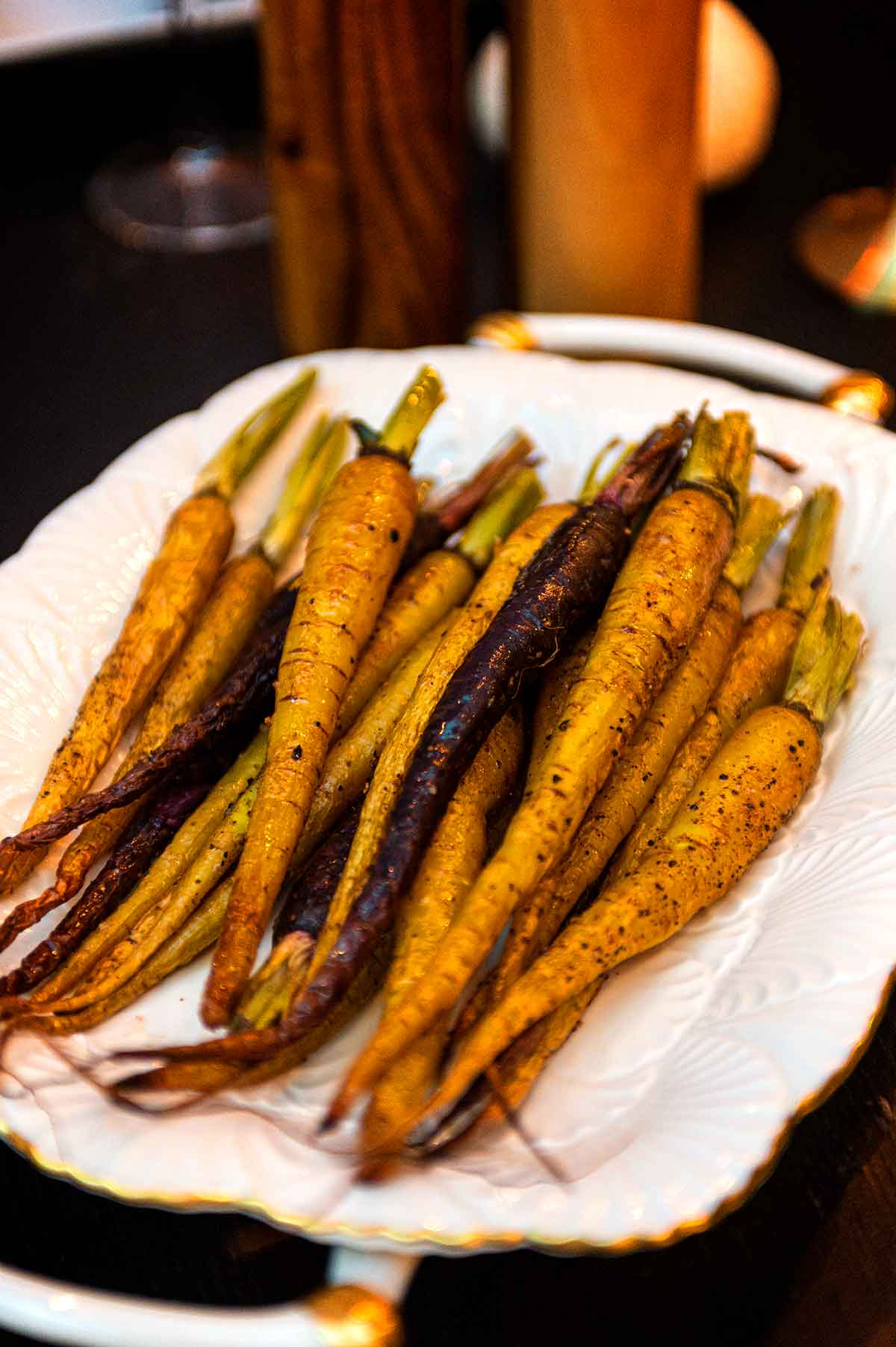A plate of roasted carrots on a table.
