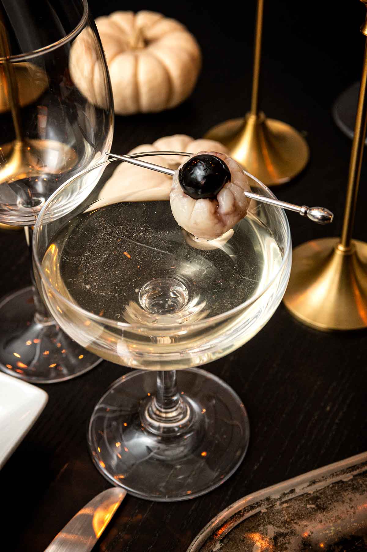 A cocktail with a garnish that looks like an eyeball.