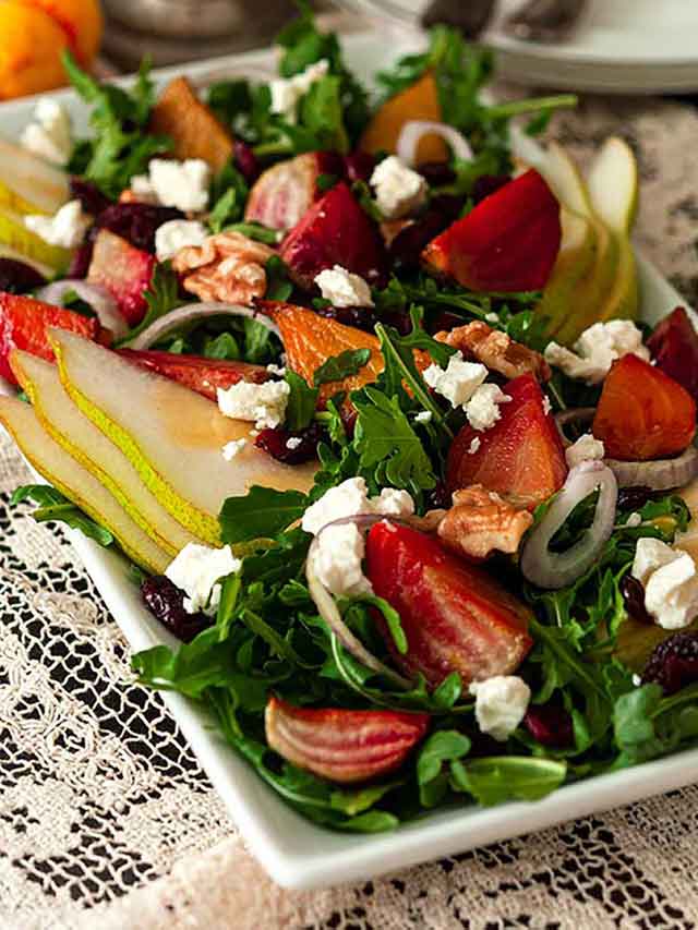 A colorful salad with beets and pears on a plate.