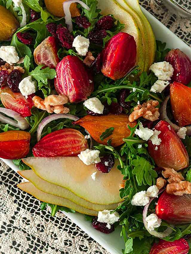 A colorful salad with beets and pears on a plate.