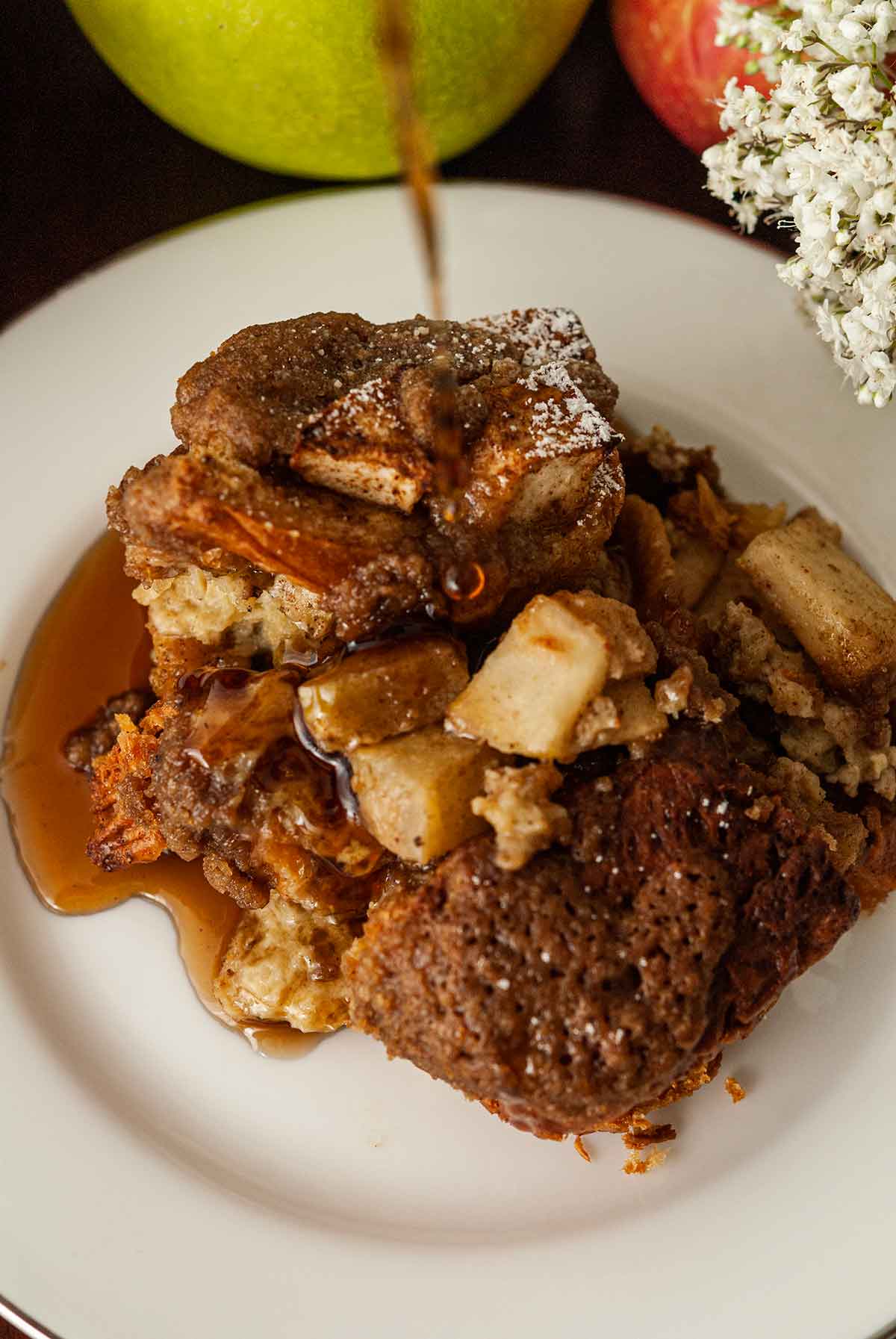 Maple syrup pouring onto a slice of chai apple french toast.