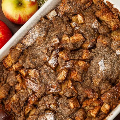 A chai apple french toast on a table beside 1 apple.