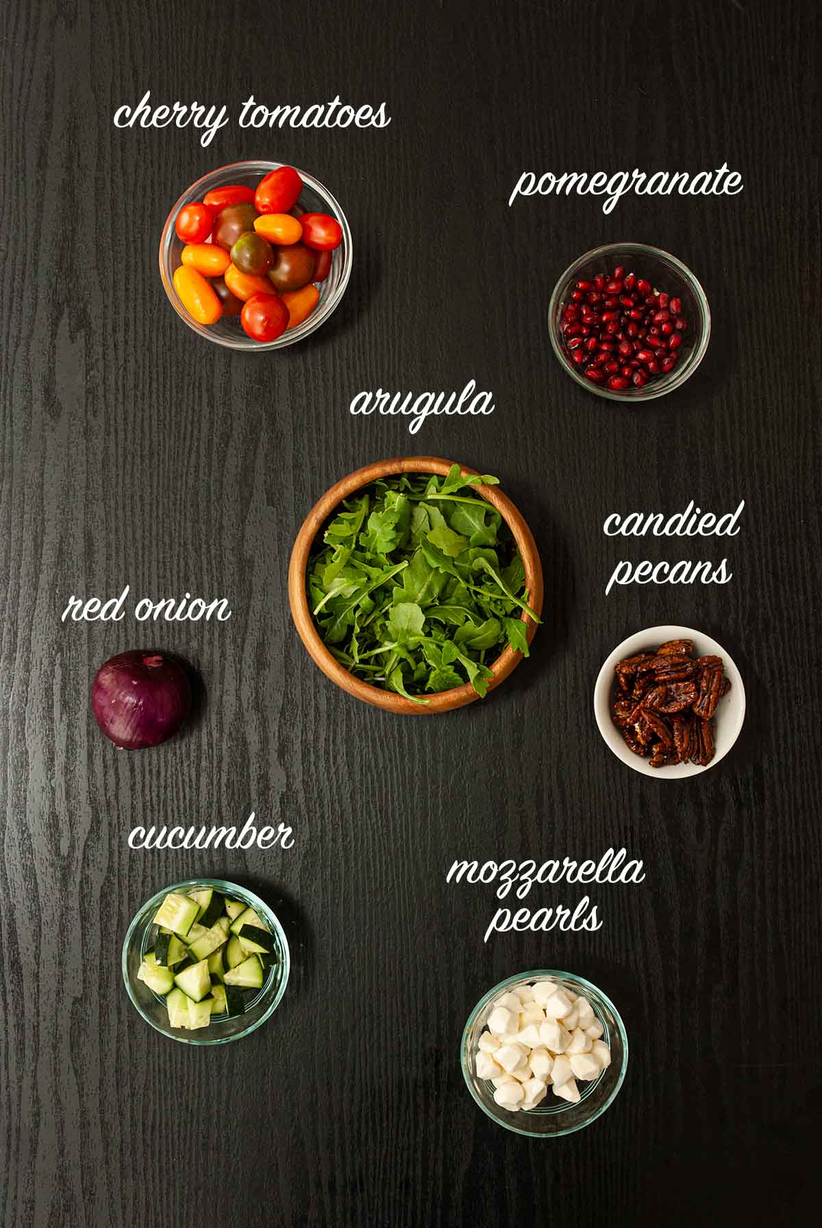 7 ingredients for making christmas salad on a table with labels describing what they are.