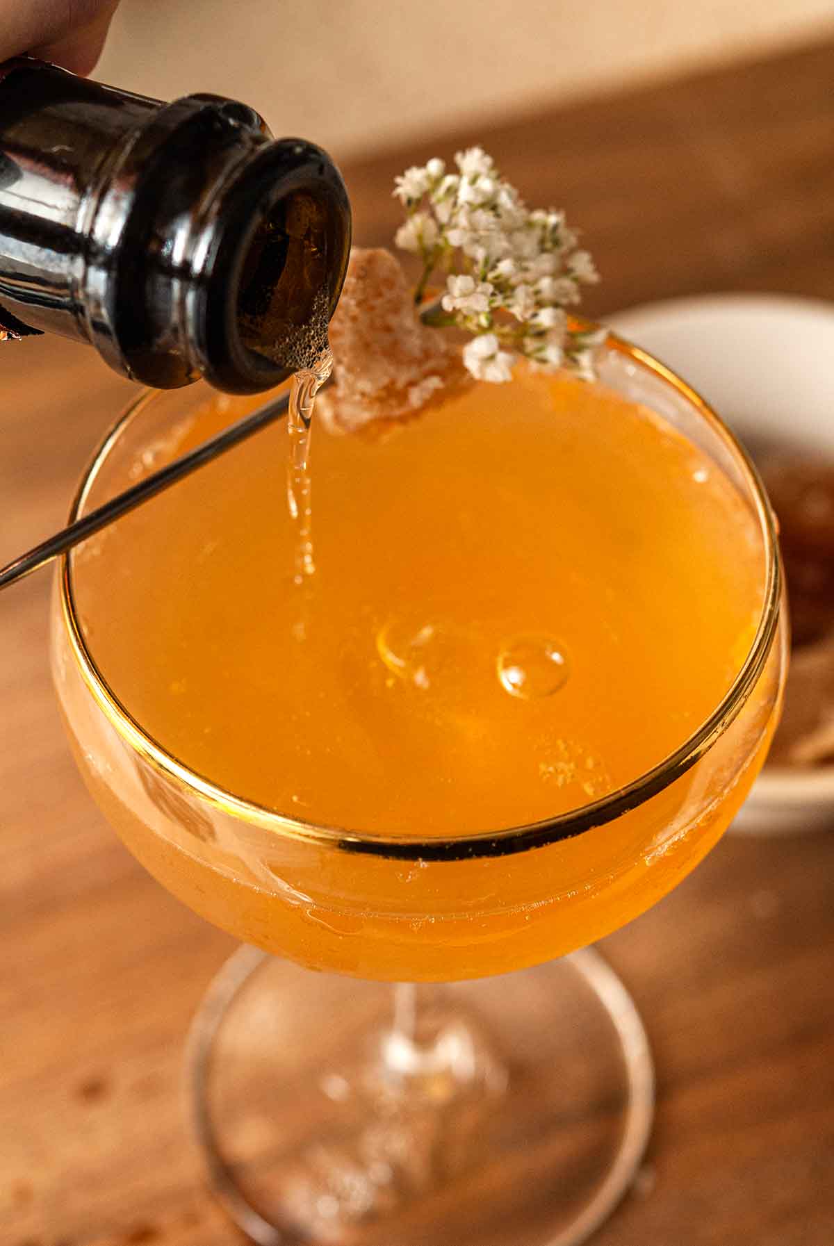 Prosecco pouring into a cocktail on a cutting board.