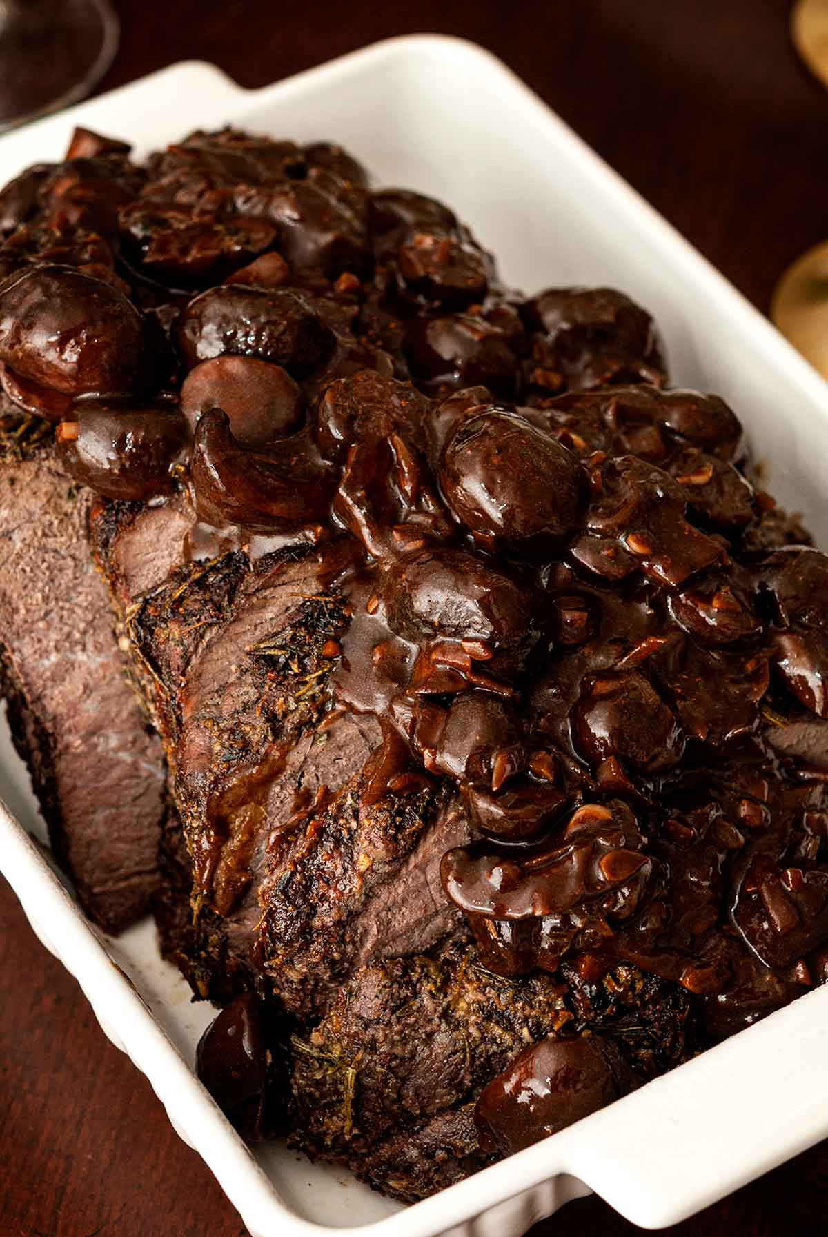 Top round roast beef in a tray with mushroom sauce.