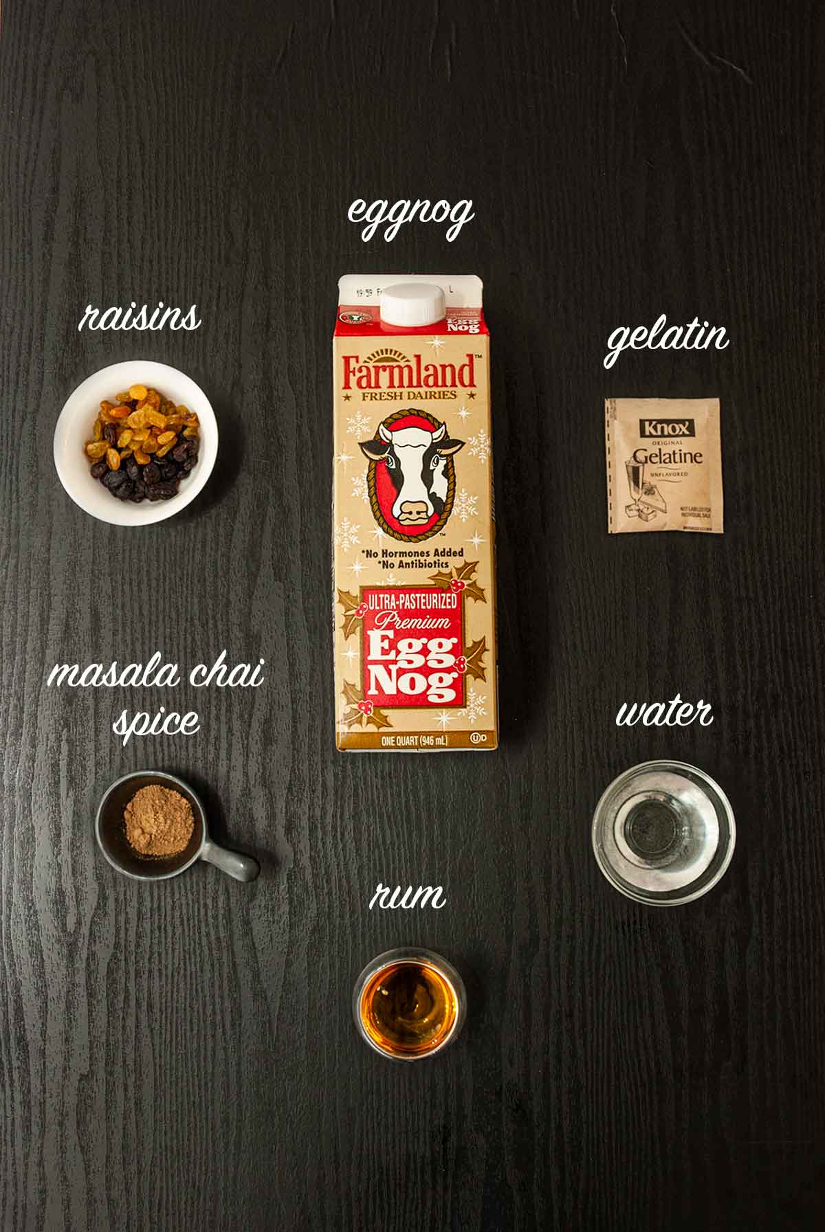 6 ingredients on a table for making eggnog panna cotta with labels.