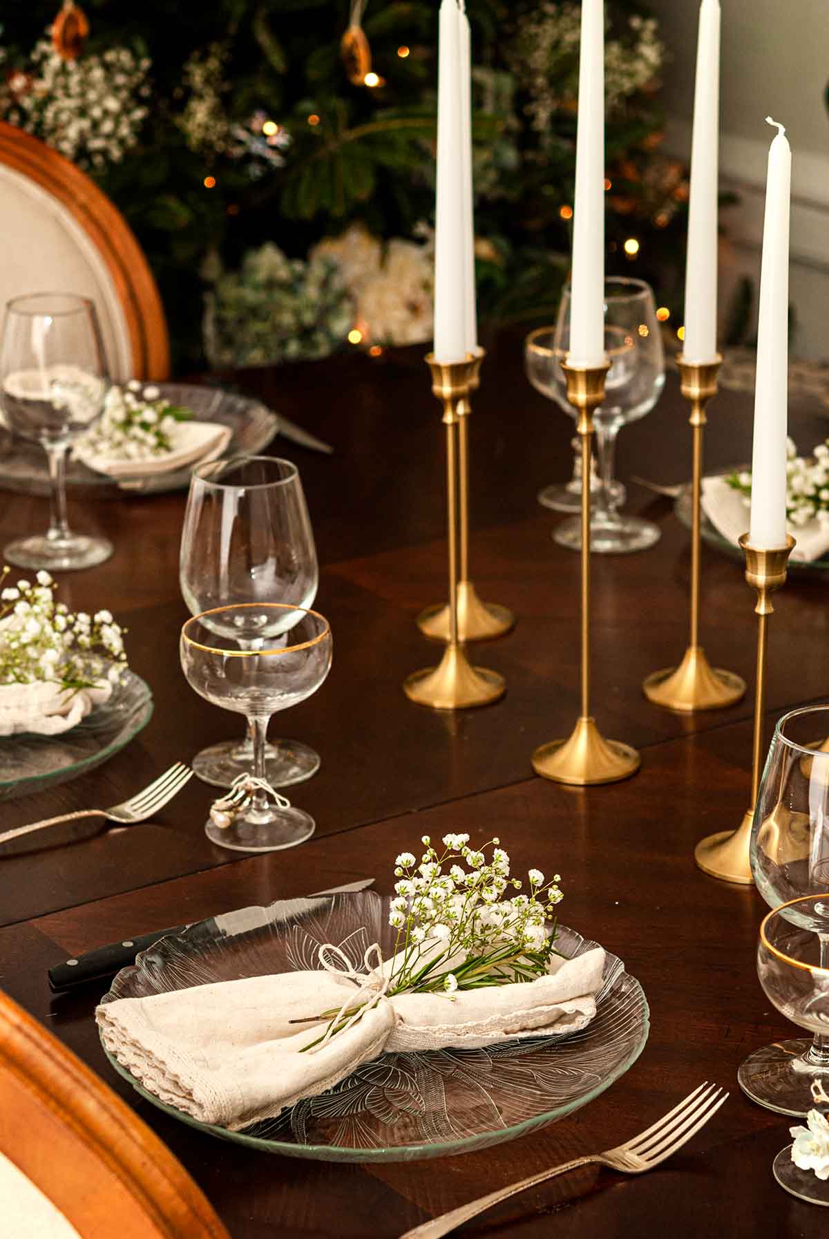 A beautifully set Christmas dinner table with baby's breath flowers in the place settings.