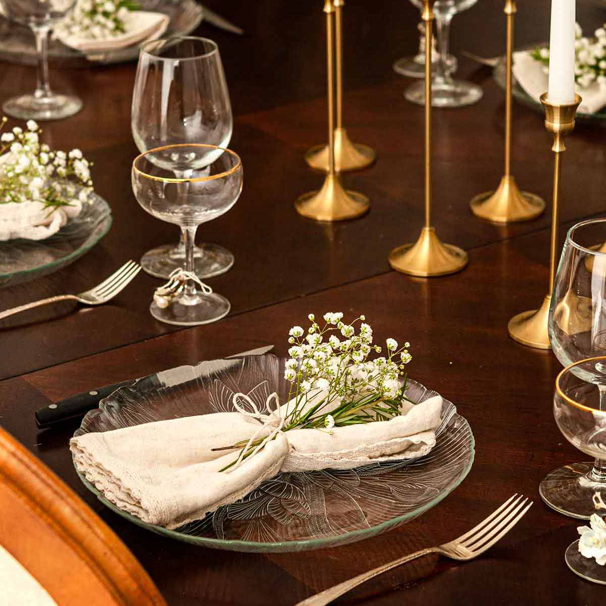 A beautifully set Christmas dinner table with baby's breath flowers in the place settings.