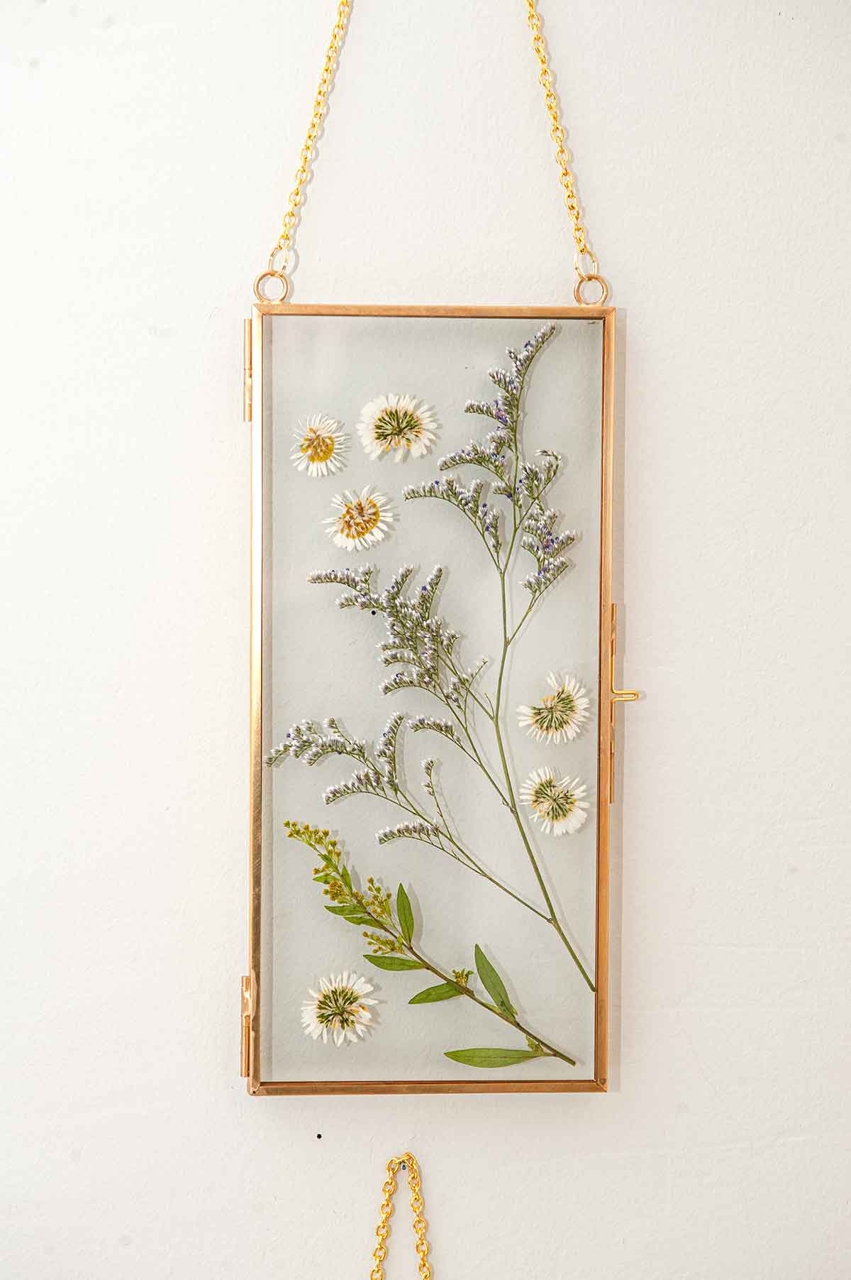 A frame with flowers on a wall.
