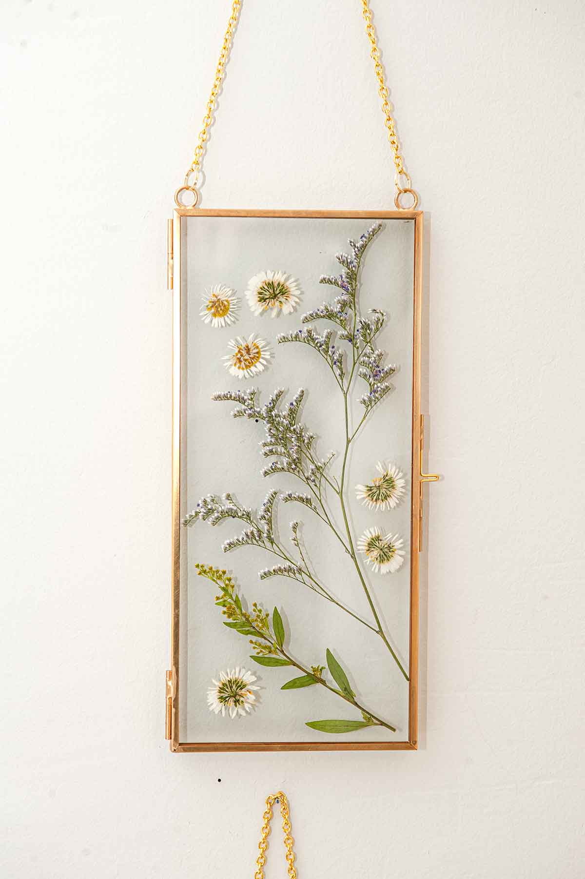 A frame with flowers on a wall.