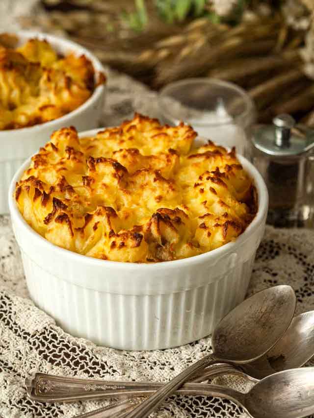 A shepherd's pie in a bowl on a lace table cloth.