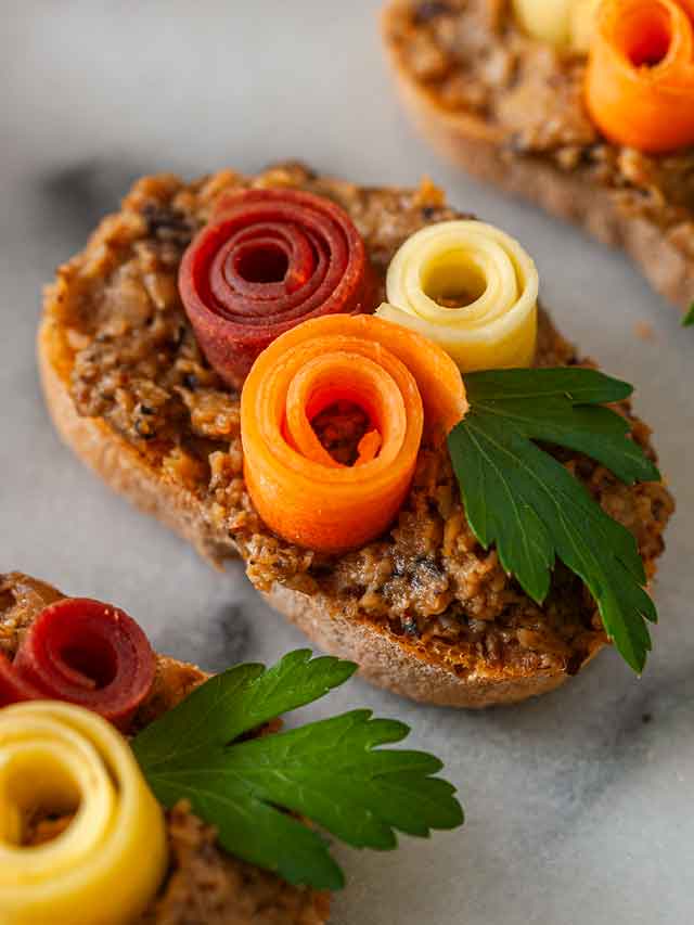 An appetizer with 3 carrot roses and a leaf.