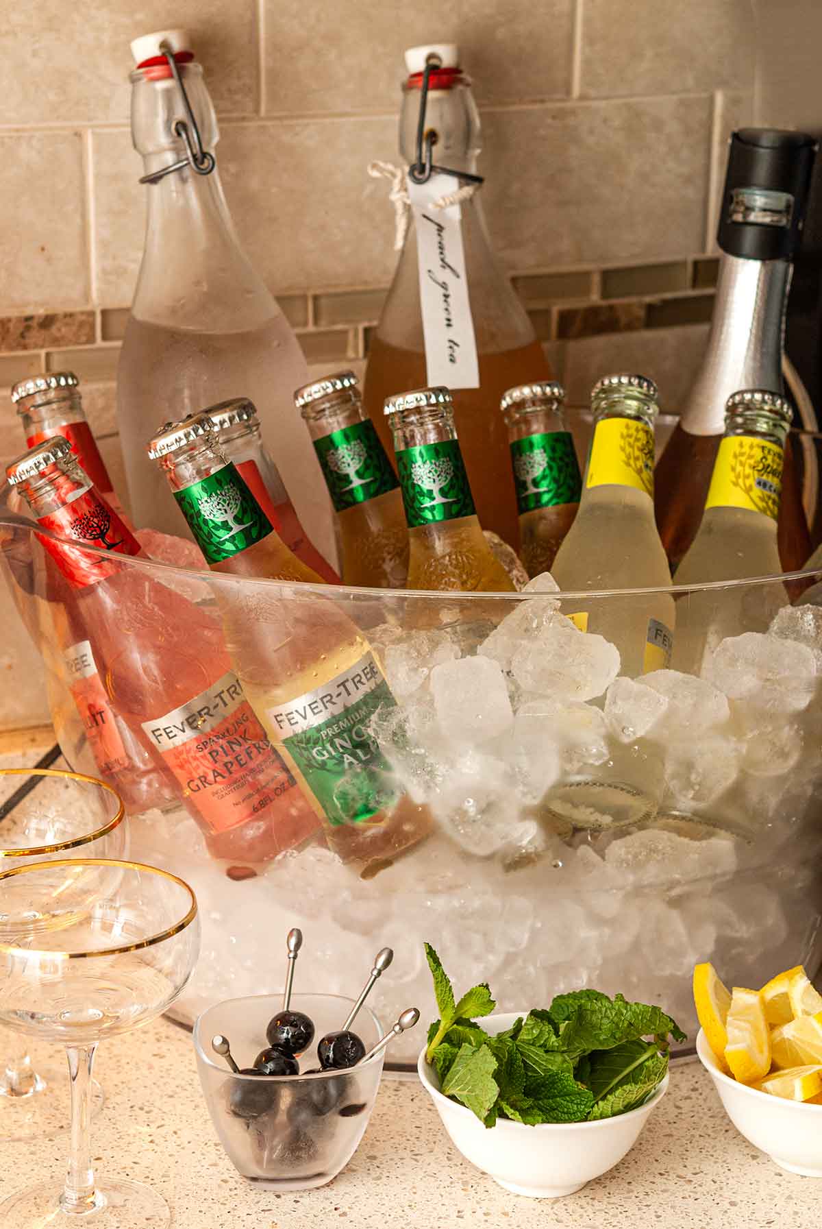 Bottles of soda, water, iced tea, and prosecco in ice.