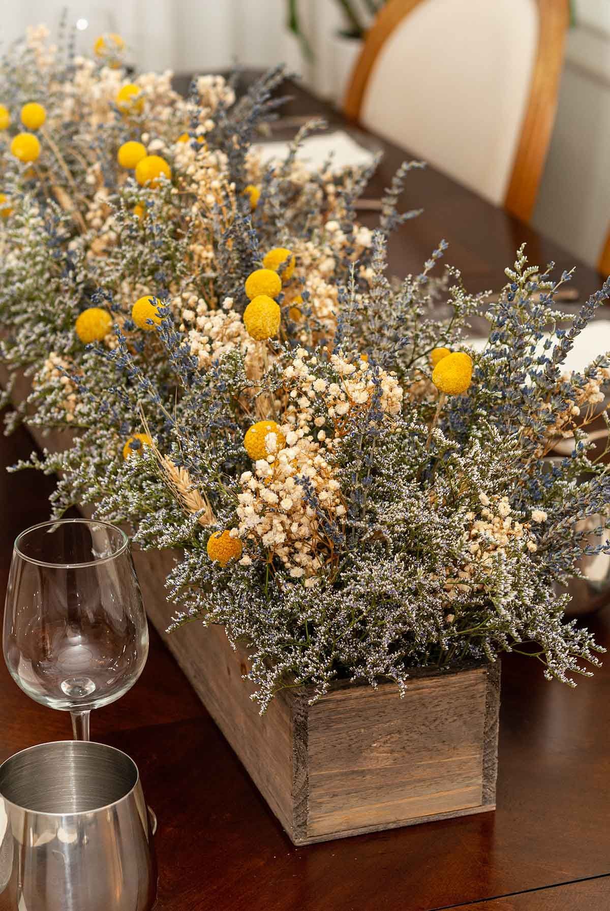 The dry flowers in a flower box centerpiece on a set table,