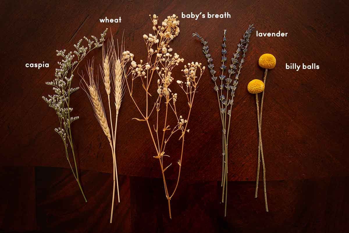 5 kinds of dry flowers on a table. Caspia, wheat, baby's breath, lavender and billy balls.