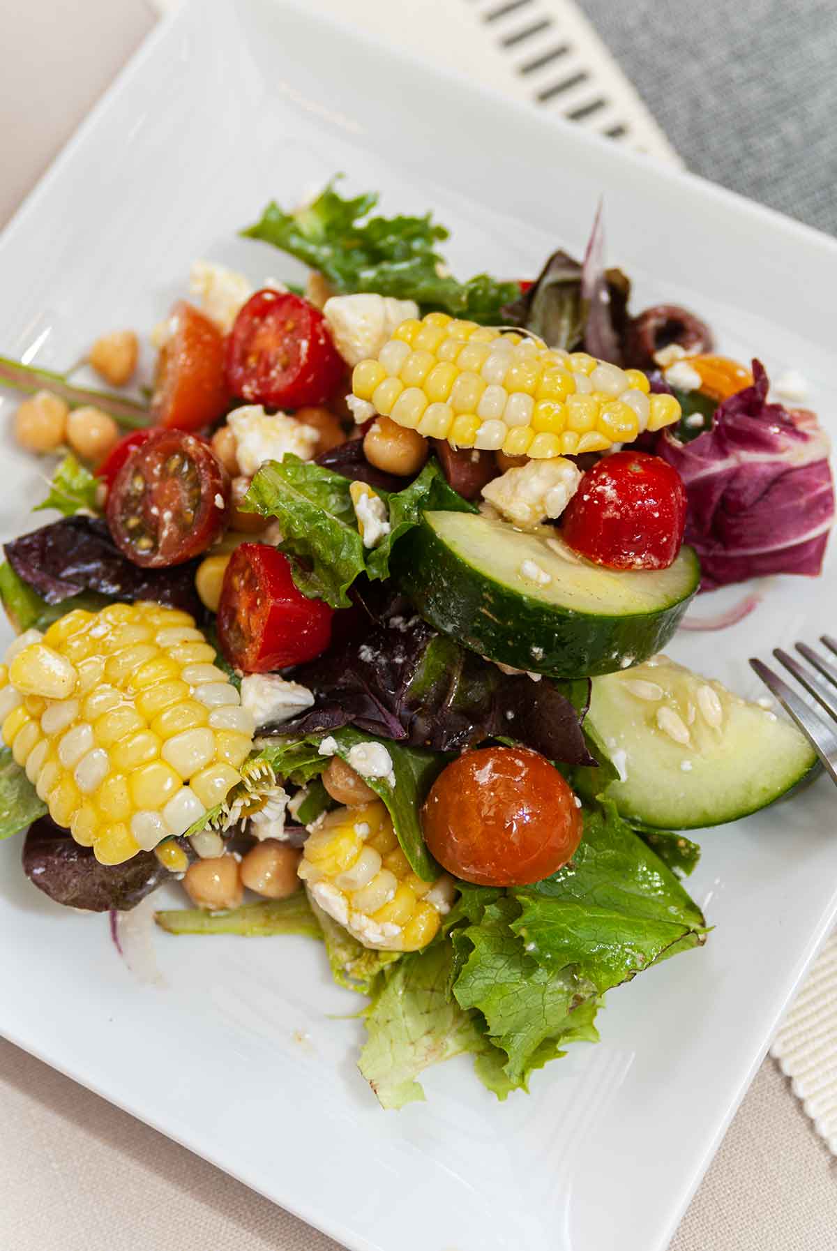 A square plate of summer corn salad.