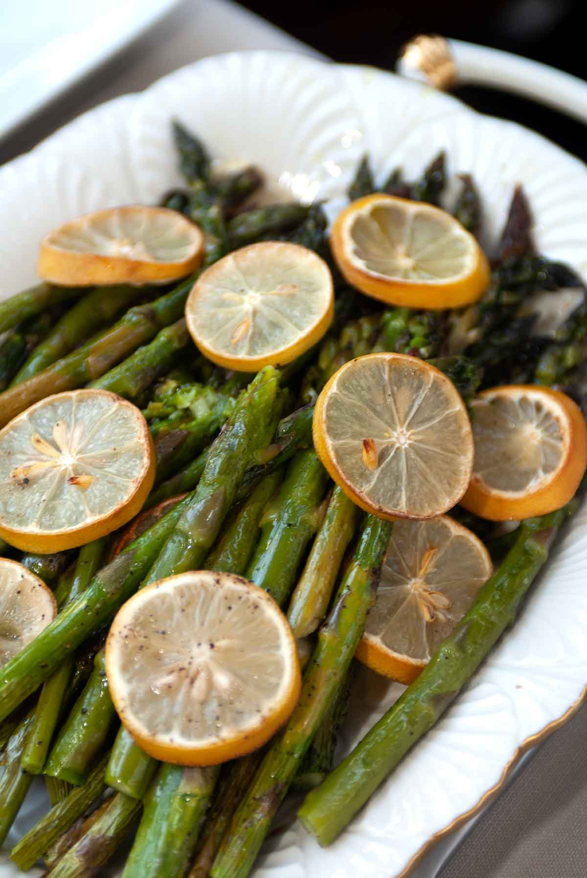 A plate of asparagus with lemon slices.