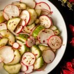 A bowl of ponzu cucumbers and radishes in a bowl.