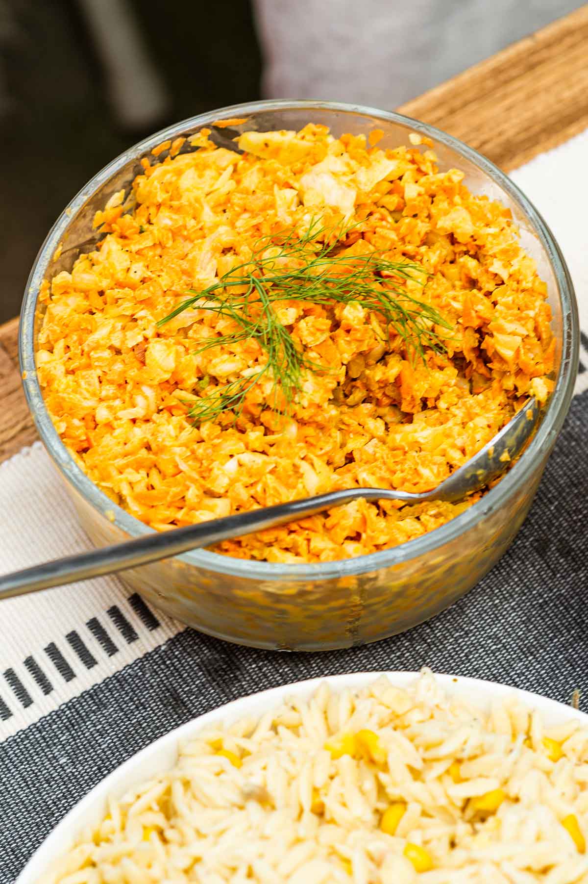 A bowl of curry coleslaw on a table.