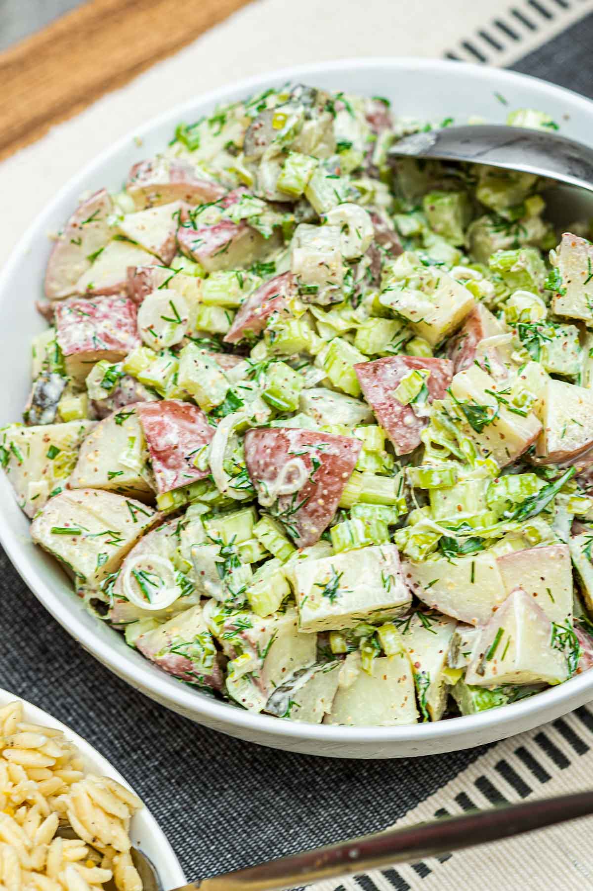 A bowl of dill potato salad on a table.
