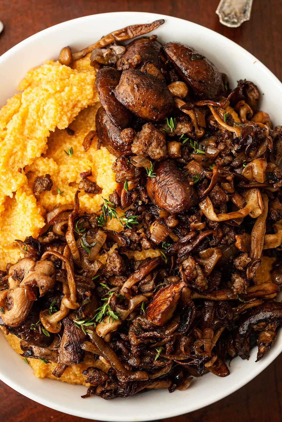 A bowl of pumpkin polenta topped with mushrooms in a bowl.