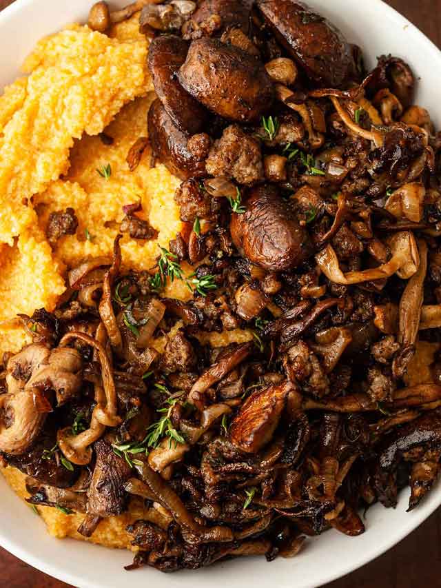 A bowl of pumpkin polenta topped with mushrooms in a bowl.