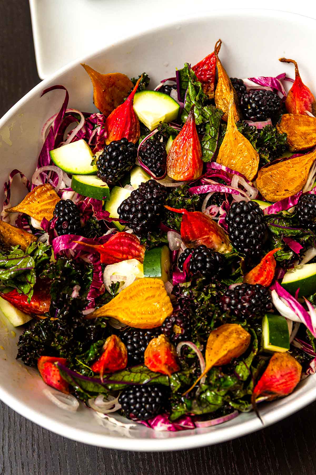 A colorful beet salad in a bowl with blackberries.