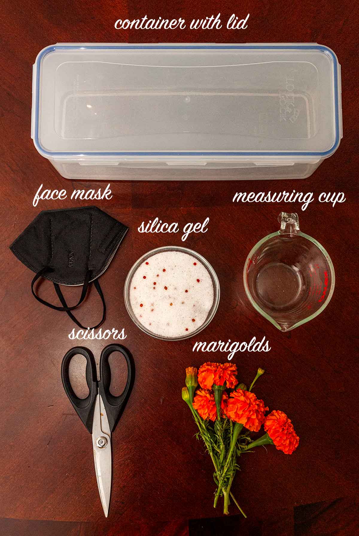 6 objects used to dry marigolds with silica gel on a table with labels describing what they are.