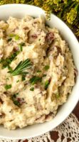 Rosemary on the top of herbed mashed potatoes in a bowl.