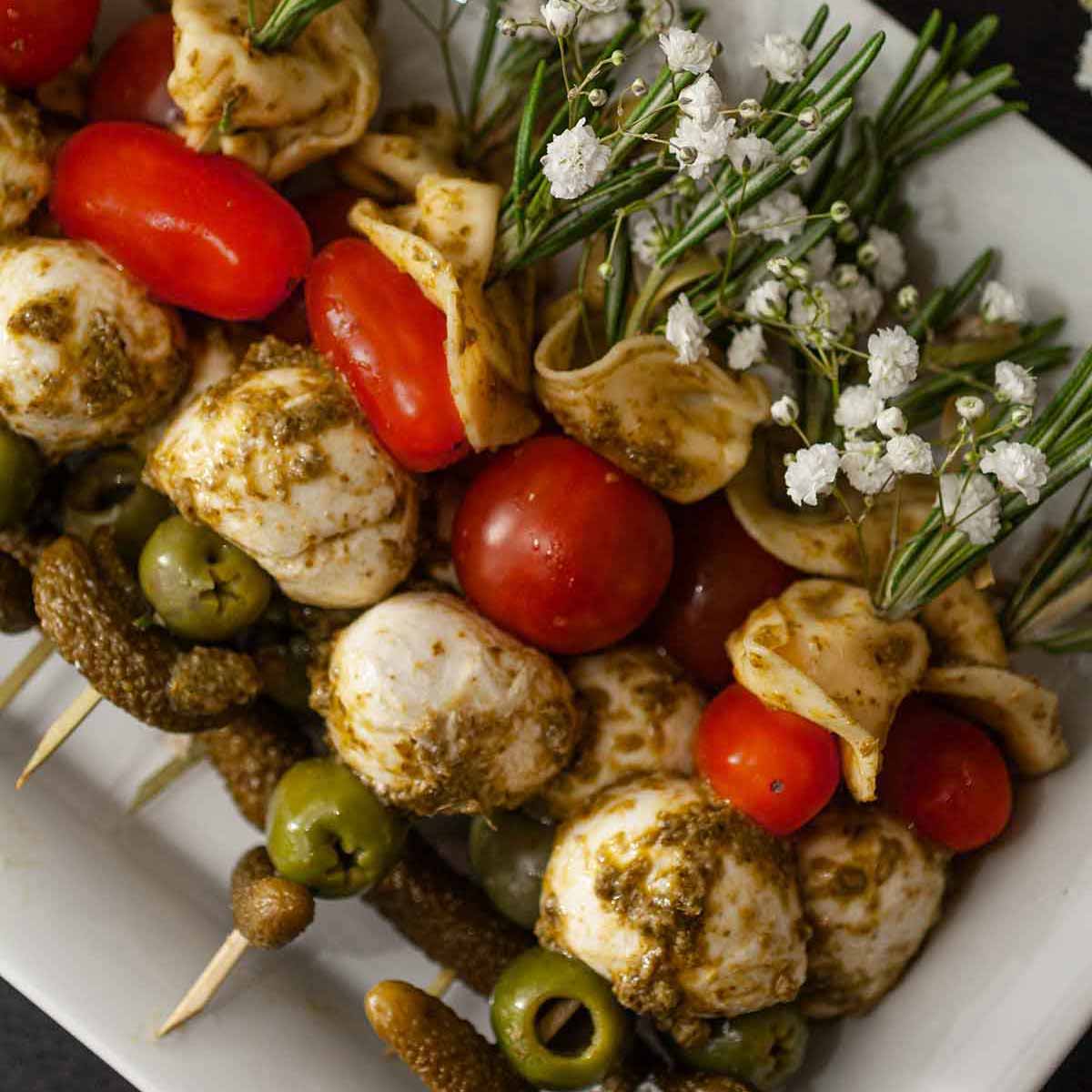 Antipasto appetizers on a plate with a title that says "10 Lovely Holiday Appetizers."