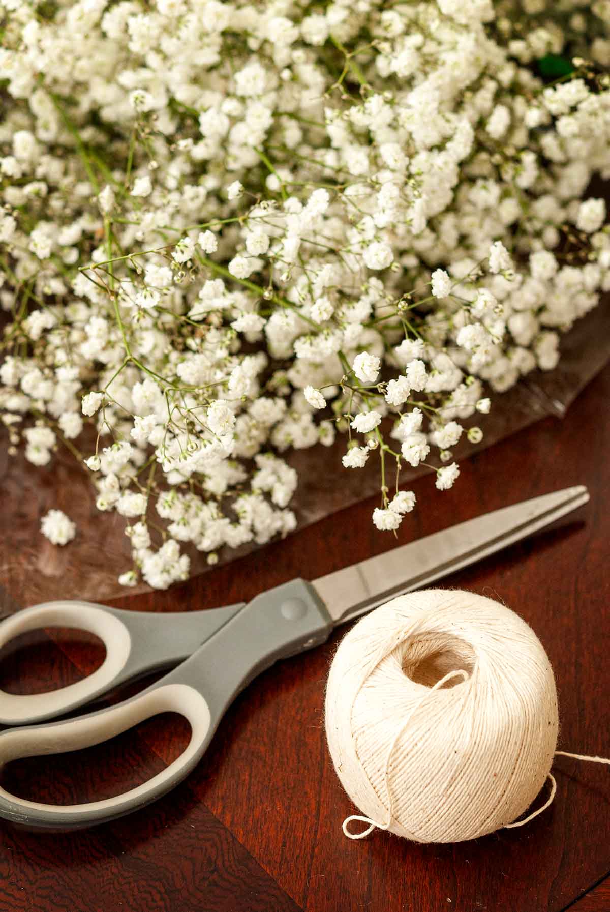 Baker's string, scissors and baby's breath on a table.