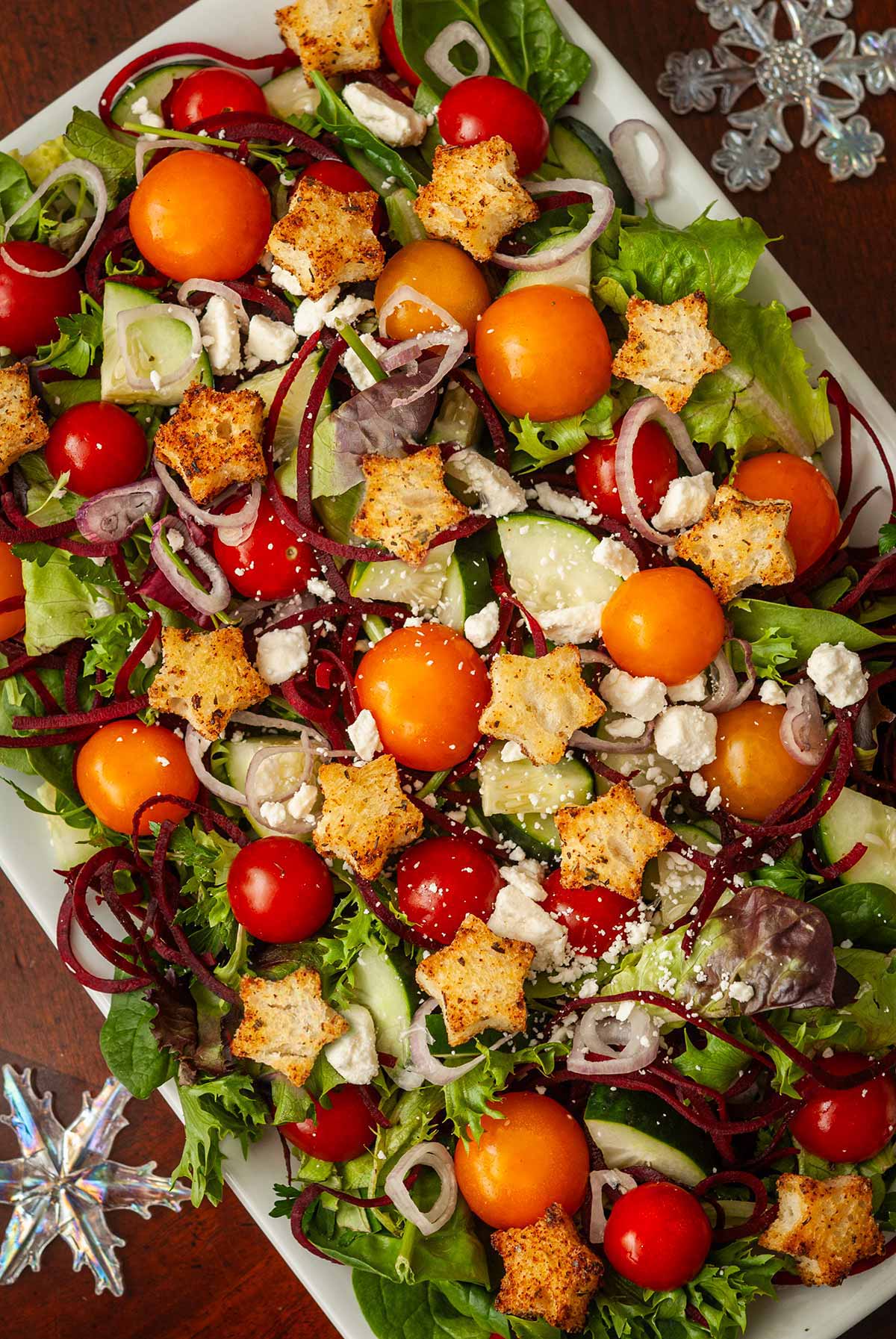 A festive salad with star-shaped croutons and snowflake ornaments in the corners.