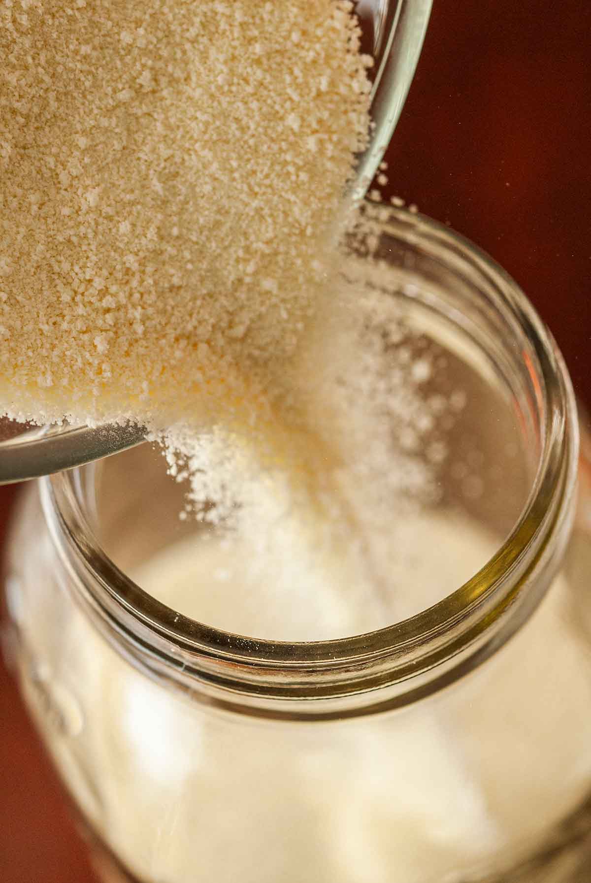 Powdered milk pouring into a jar.