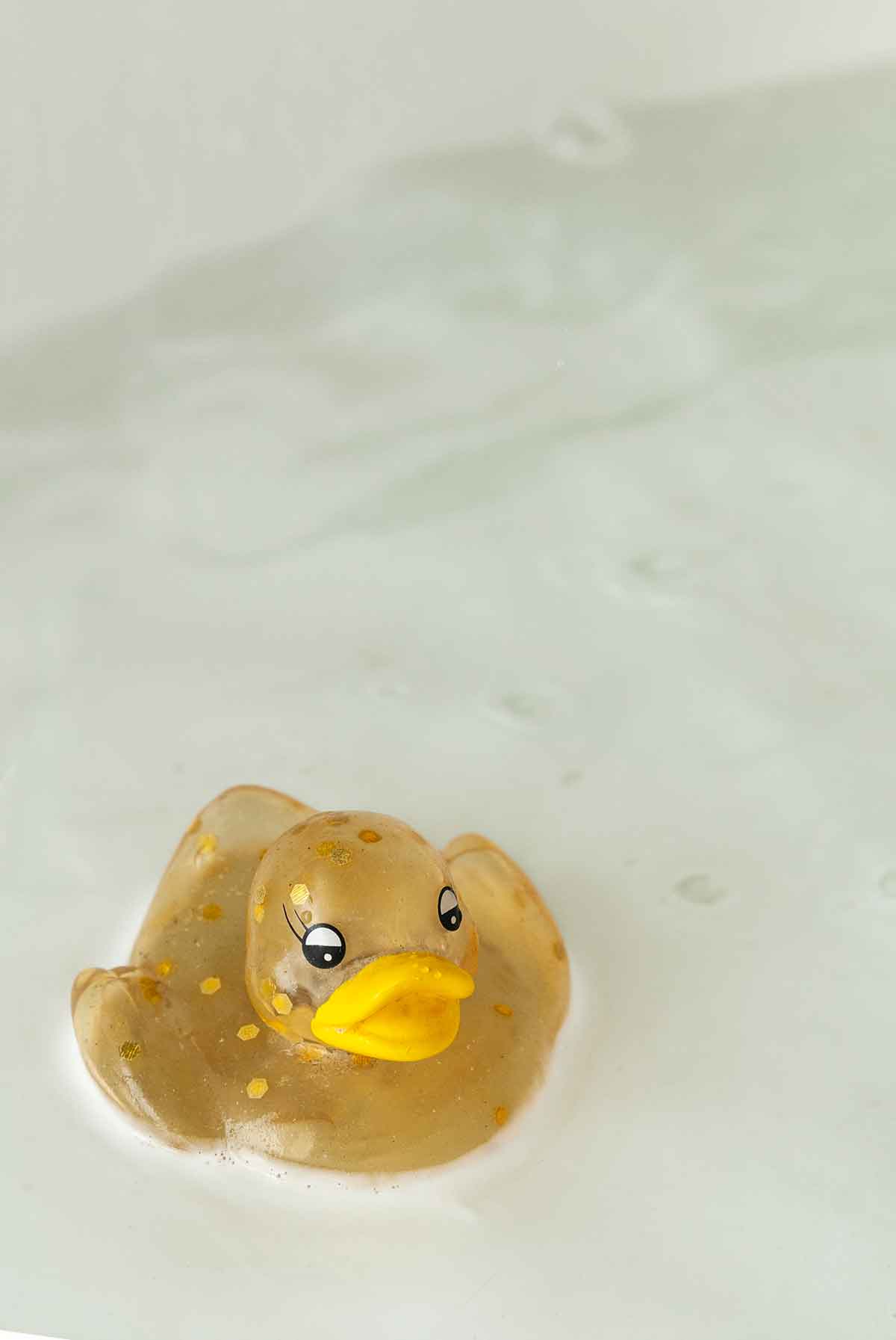 A rubber duck in a milky tub.