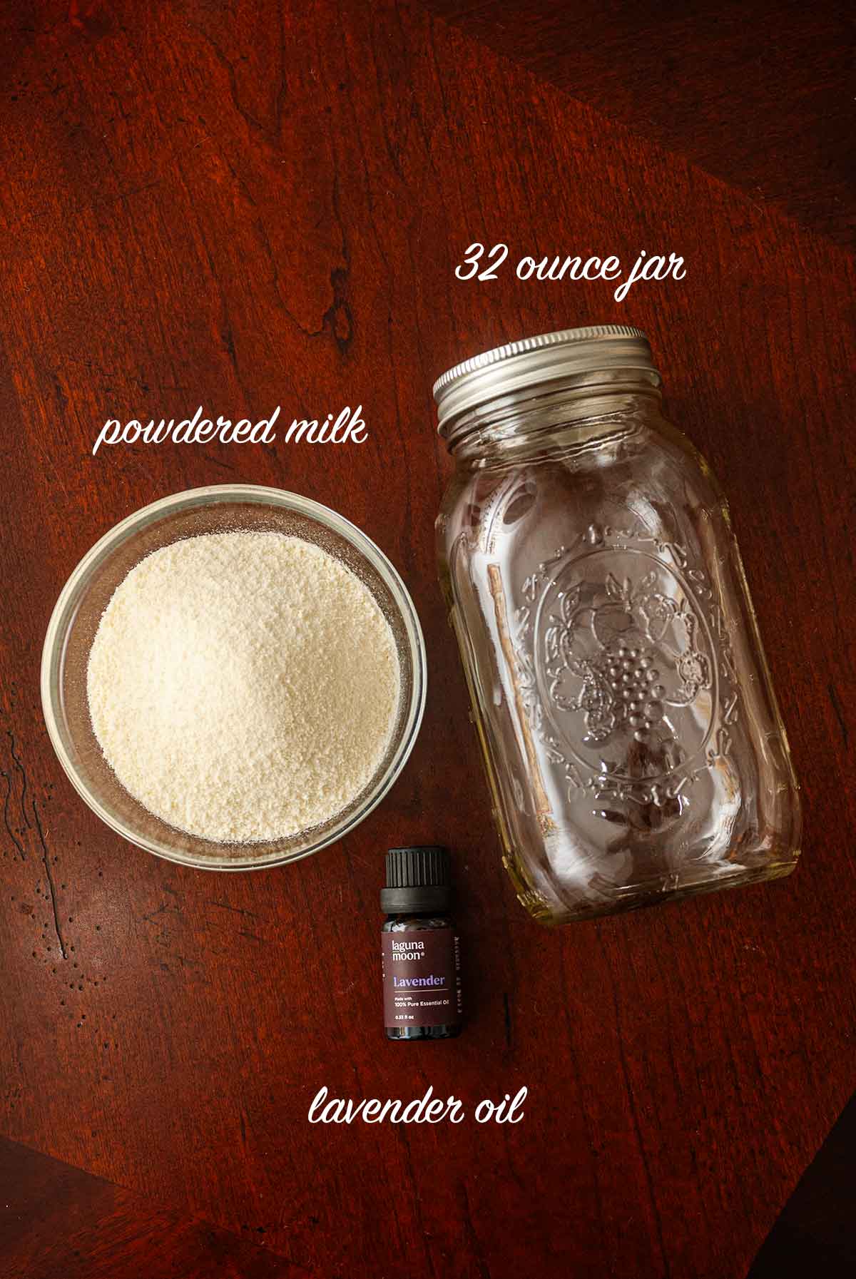 A bowl of powdered milk, a jar and bottle of lavender oil on a table.