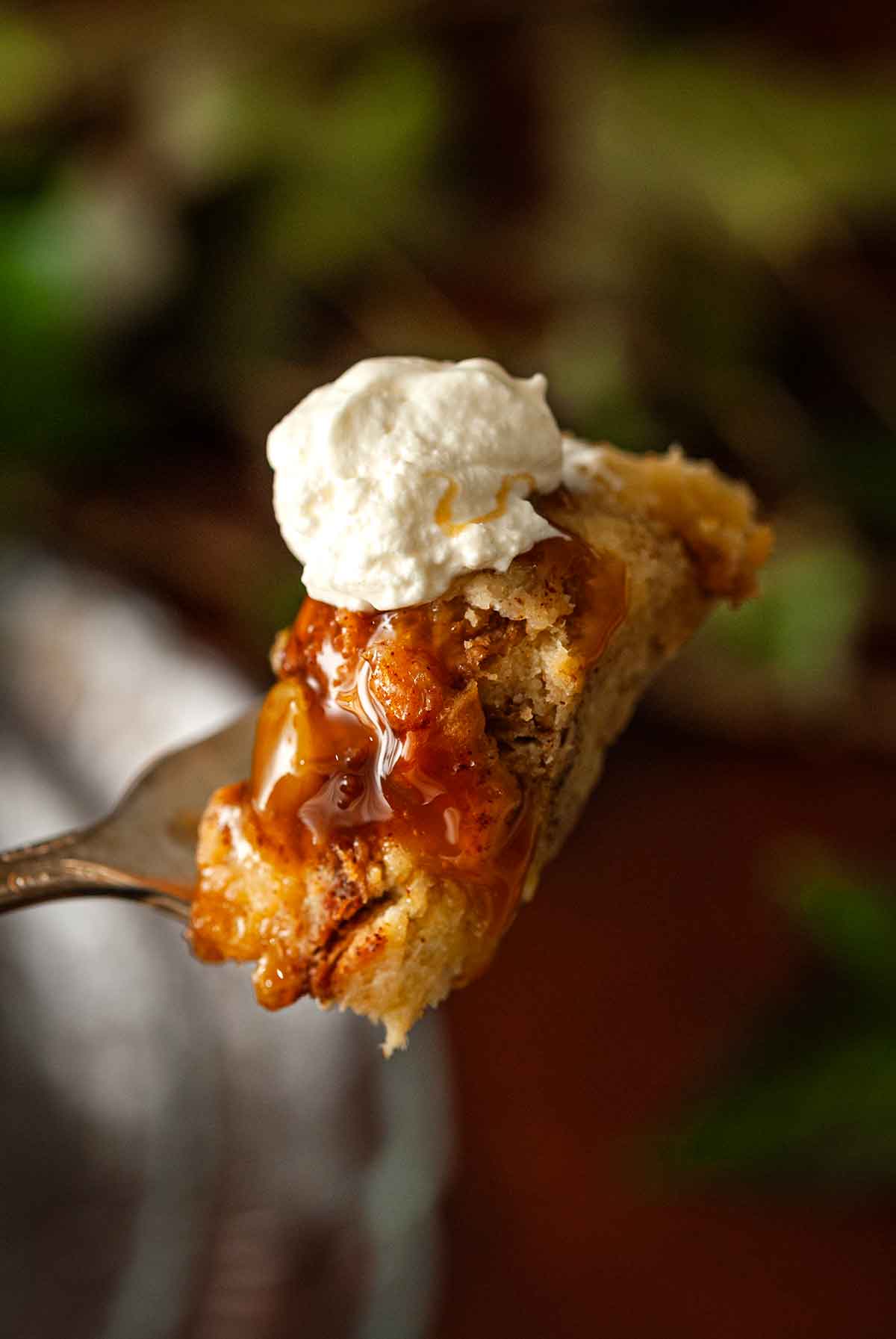 A fork of bread putting with cream on top.