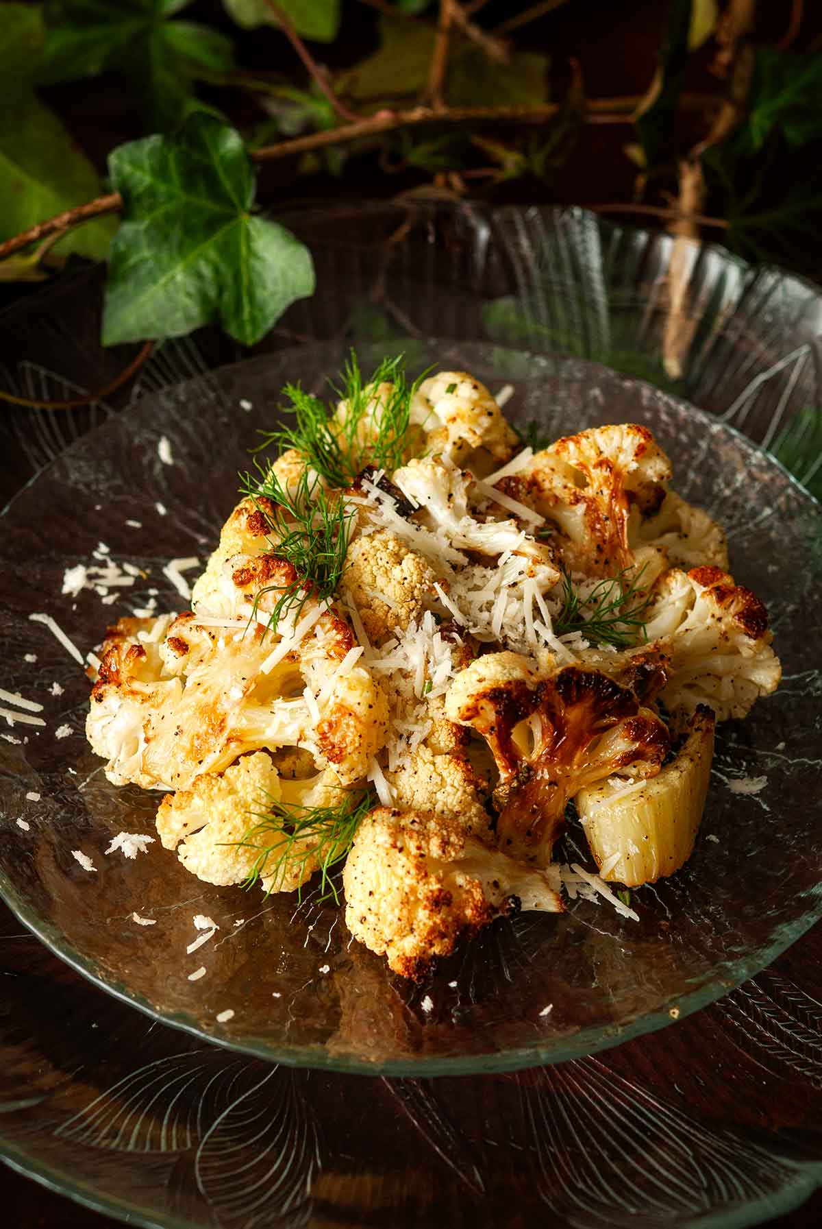 A plate of cauliflower and fennel surrounded by ivy on a table.
