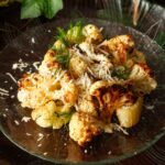 A plate of cauliflower and fennel surrounded by ivy on a table.