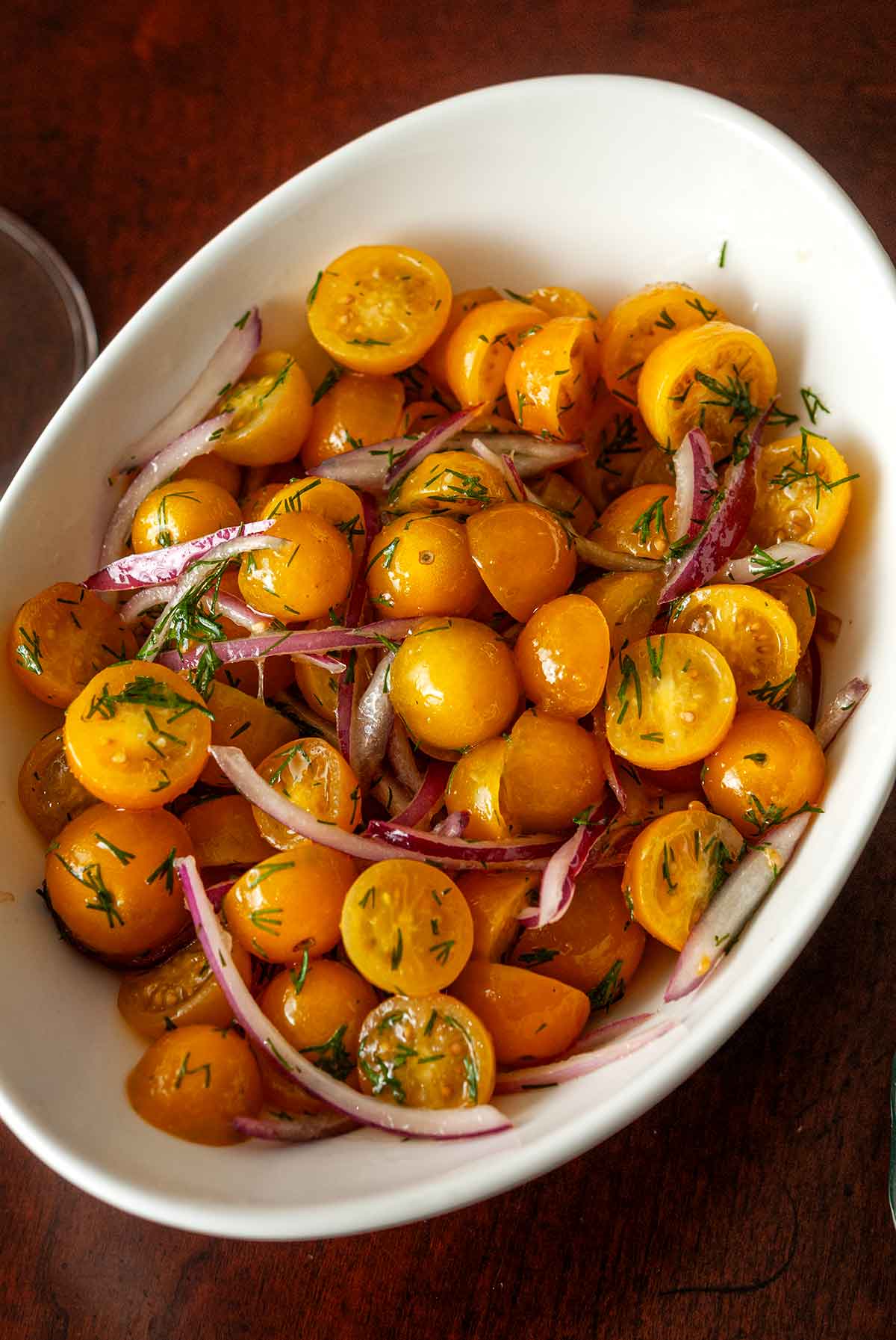 A bowl of cherry tomatoes and onions in a bowl.