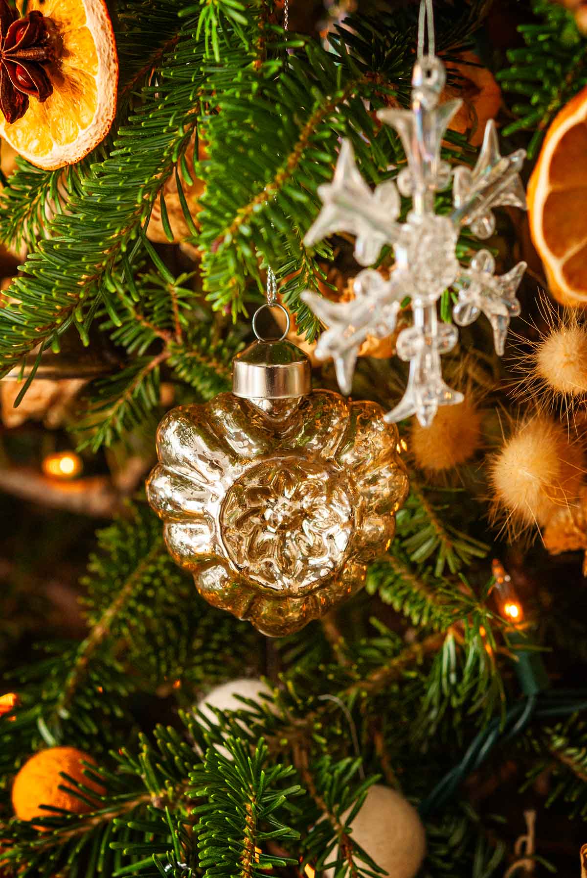 A heart-shaped blown glass ornament in a Christmas tree.