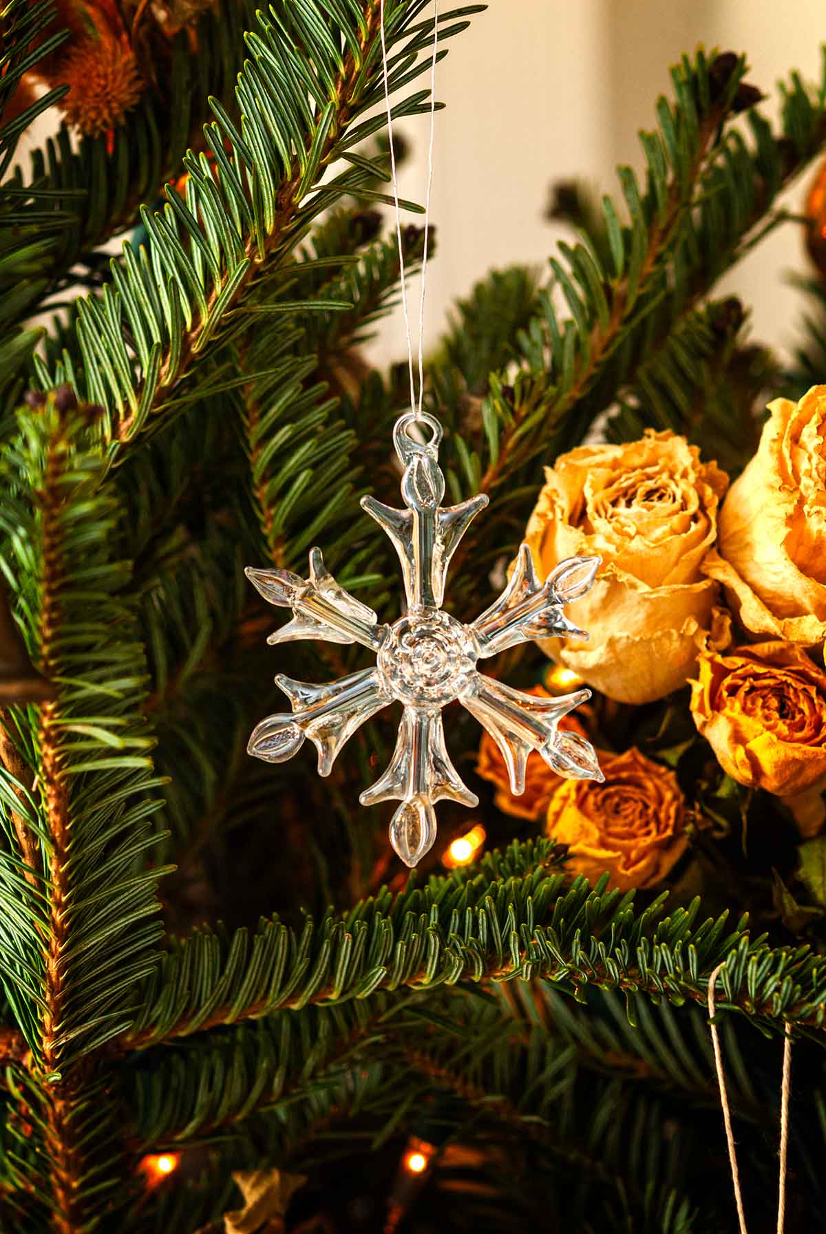 A glass snowflake ornament in a Christmas tree.