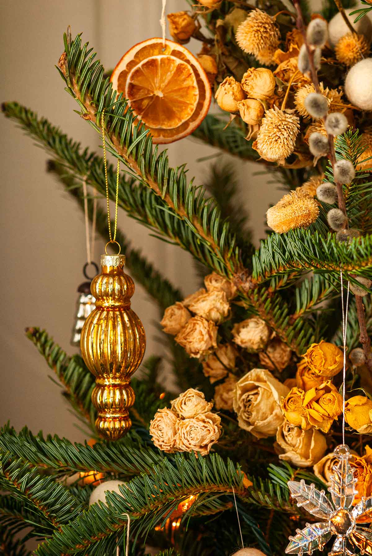 Blown glass ornaments and citrus ornaments in a Christmas tree.
